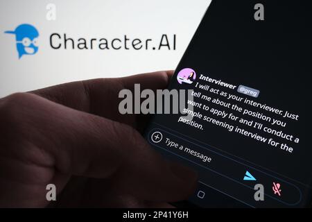 Esempio di chatbot ai del personaggio visualizzato sullo schermo dello smartphone. Carattere sfocato.ai logo sullo sfondo. Stafford, Regno Unito, 5 marzo 2023 Foto Stock