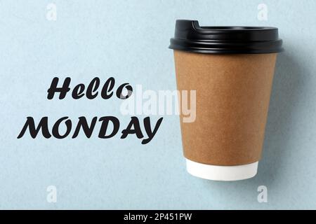 Ciao Lunedi, iniziare la settimana con buon umore. Tazza di carta su sfondo azzurro, vista dall'alto Foto Stock