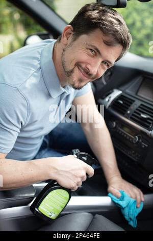 l'uomo lava l'interno di un'auto in un autolavaggio Foto Stock