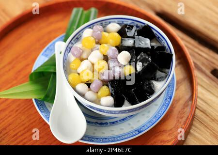 Gelatina di erba nera cinese Dessert con palle di Taro, servita con latte di cocco dolce. Cincau Hitam Foto Stock