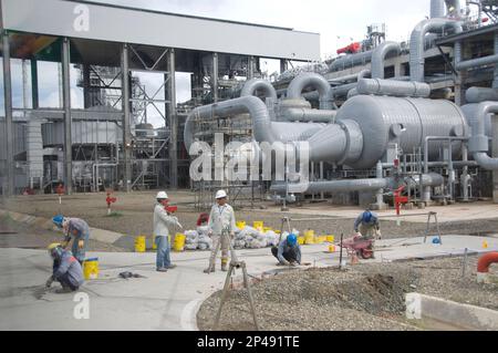 Operai che fissano la strada, tubazioni e navi, Tangguh GNL (gas naturale liquefatto) pianta. Vicino a Babo, Papus Occidentale, Indonesia Foto Stock