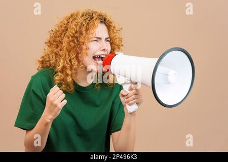 Donna sconvolta con capelli ricci urla usando un altoparlante Foto Stock
