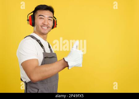 Falegname cinese maschio gesturando l'approvazione con pollice in su Foto Stock