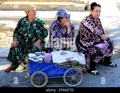 Donne uzbeke che vendono tè da una vecchia carrozza vintage a Bukhara, Uzbekistan. Foto Stock