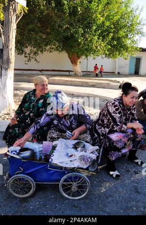 Donne uzbeke che vendono tè da una vecchia carrozza vintage a Bukhara, Uzbekistan. Foto Stock