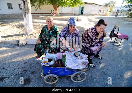 Donne uzbeke che vendono tè da una vecchia carrozza vintage a Bukhara, Uzbekistan. Foto Stock