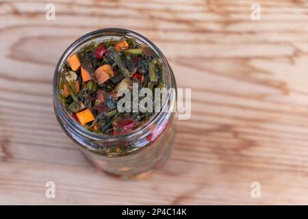 Verdure caserecce in vaso di vetro su sfondo di legno. Foto Stock