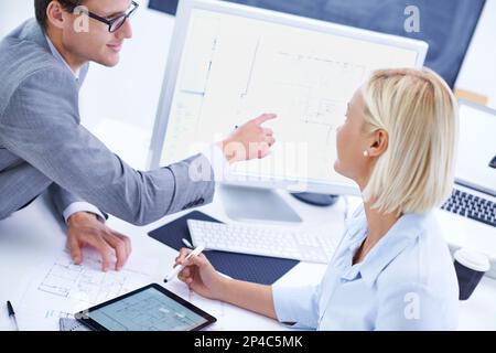 Utilizzo della tecnologia moderna per una pianificazione rapida. un architetto che mostra qualcosa su un computer al suo collega. Foto Stock