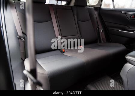 Primo piano sui sedili posteriori con rivestimento in tessuto velluto all'interno di una vecchia vettura coreana in grigio dopo la pulizia a secco. Settore dell'assistenza auto. Foto Stock