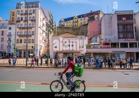 Un Uber mangia consegnare autista su una bicicletta a Lisbona, Portogallo Foto Stock