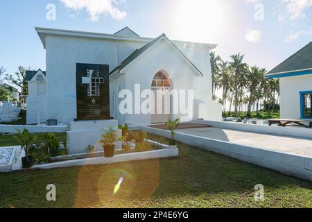 Aitutaki Cook Islands - 8 2010 novembre; percorso che conduce a Ziona tapu segno su porta chiusa chiesa bianca con sole dietro ed effetto lente-flare. Foto Stock