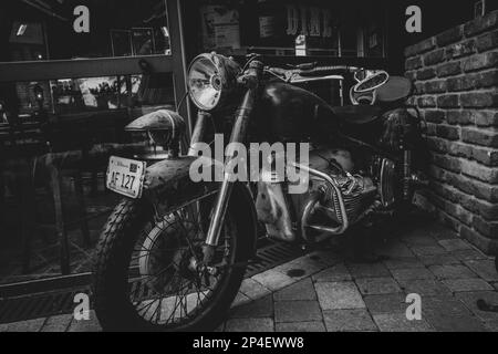 una motocicletta molto vecchia si trova all'ingresso di un ristorante Foto Stock