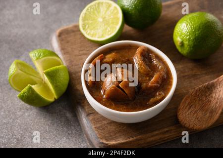 Tradizionale filone di lime dello Sri Lanka, sale, peperoncino, pepe su fondo marrone. Primo piano. Foto Stock