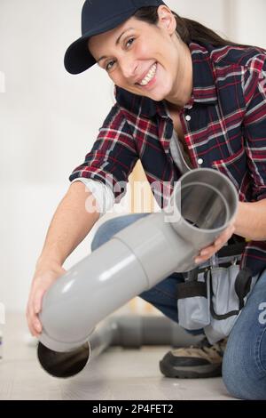 idraulico femmina che collega tubi in plastica Foto Stock