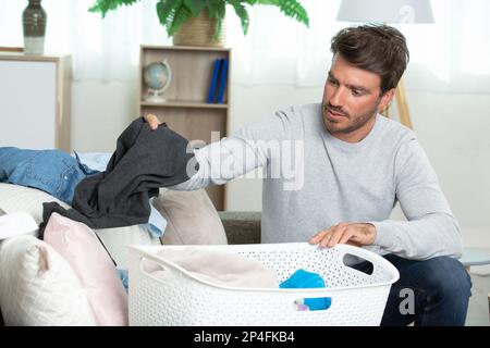 ritratto di un uomo con un cesto di bucato pulito Foto Stock