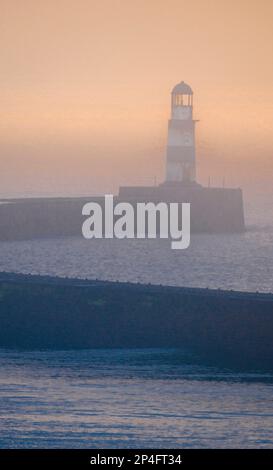 Faro di Seaham in una mattinata invernale nebbiosa scattata con un teleobiettivo. Contea di Durham Inghilterra Foto Stock