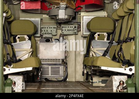 L'interno di un veicolo da combattimento di fanteria blindata con file di sedili e una console di monitoraggio. Foto Stock