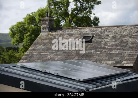 Pannelli di energia solare attaccati al garage per fornire elettricità per una casa in un ambiente rurale, Inghilterra, Regno Unito Foto Stock