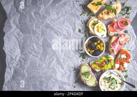 Panini assortiti e sani sfondo. Sandwich bar o buffet. Ciabatta panini con salse, pesce, formaggio, carne, verdure, frutta. Spazio per Foto Stock