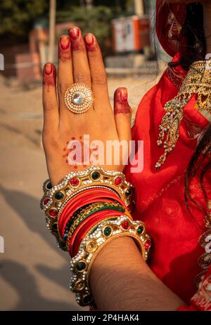 India, Rajasthan, Bikaner, Camel Festival Parade, mani di Rajasthan donna in sari rosso facendo gesto Namaste Foto Stock