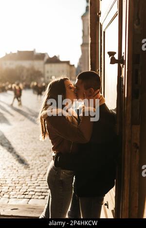 l'uomo e la donna baciano e si abbracciano nei raggi del sole d'autunno Foto Stock