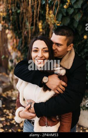 Felice coppia che abbraccia il folgore intorno nel parco autunnale Foto Stock