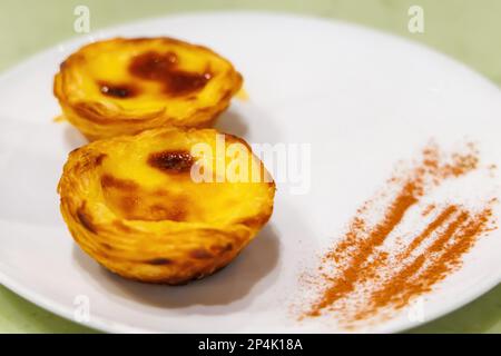 Pastéis de nata, pastel de nata. Crostata alla crema di uova portoghese, fresca di forno, servita con cannella. Dessert in Portogallo. Messa a fuoco selettiva. Foto Stock