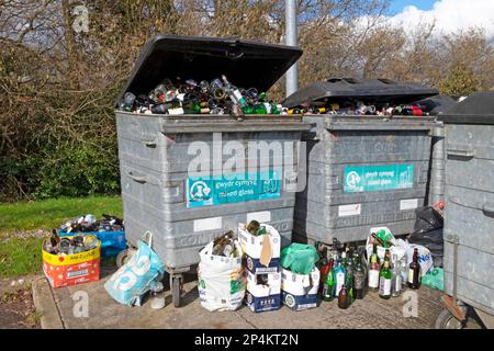 Bottiglie di vetro in contenitori a bidoni e al suolo presso la stazione di riciclaggio delle bottiglie nel Carmarthenshire Wales UK 2023. KATHY DEWITT Foto Stock