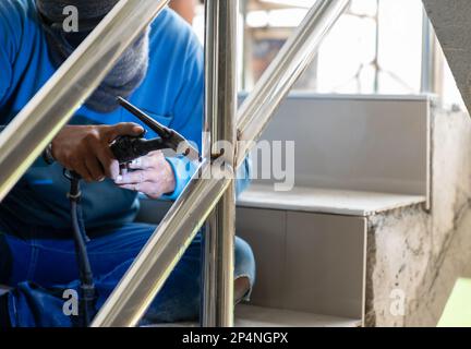 Binario di saldatura ad argon del lavoratore in cantiere. Foto Stock