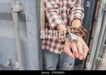 Donna intrappolata nel contenitore di carico attendere il traffico di esseri umani o lavoratori di fronte, donna che tiene la chiave padronale in attesa di aiuto holp, donna incatenata al suo wrinis Foto Stock