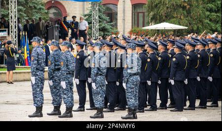 Un gruppo di soldati in uniforme, in piedi con un ufficiale senior dietro di loro in un'area all'aperto Foto Stock