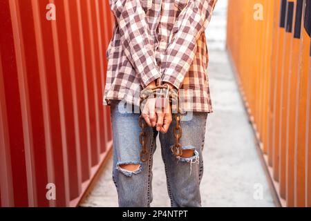 Donna intrappolata nel contenitore di carico attendere il traffico di esseri umani o lavoratori di fronte, donna che tiene la chiave padronale in attesa di aiuto holp, donna incatenata al suo wrinis Foto Stock