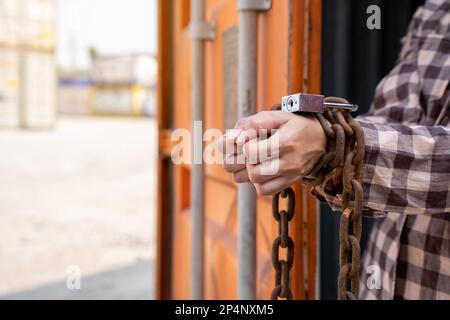 Donna intrappolata nel contenitore di carico attendere il traffico di esseri umani o lavoratori di fronte, donna che tiene la chiave padronale in attesa di aiuto holp, donna incatenata al suo wrinis Foto Stock