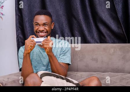 Foto di un bel ragazzo domestico rilassante soggiorno a casa quarantena tempo di giocare a videogiochi playstation football Foto Stock