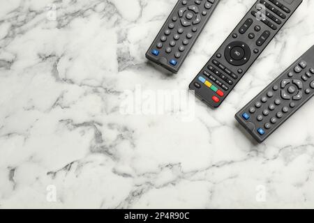 TV moderna con telecomando su un tavolo in marmo bianco, piatto. Spazio per il testo Foto Stock