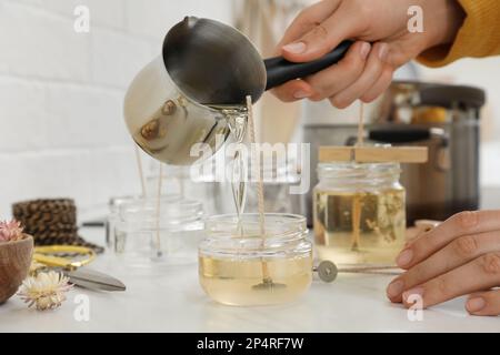 Donna che fa candele a tavola bianca, primo piano Foto Stock