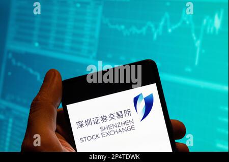 Cina. 19th Feb, 2023. In questa foto, il logo dell'indice della borsa di Shenzhen è visualizzato su uno smartphone con un grafico dell'indice della borsa economica sullo sfondo. Credit: SOPA Images Limited/Alamy Live News Foto Stock