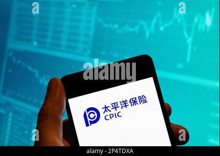 Cina. 19th Feb, 2023. In questa foto, il logo della compagnia di assicurazioni cinese China Pacific Insurance (CPIC) viene visualizzato su uno smartphone con un grafico dell'indice della borsa economica sullo sfondo. Credit: SOPA Images Limited/Alamy Live News Foto Stock