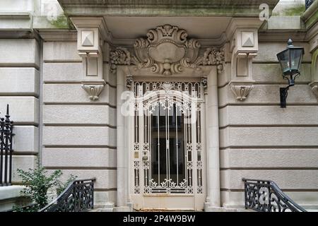 Manhattan, elegante entrata della casa cittadina con griglia in ferro battuto ornata sulla porta Foto Stock