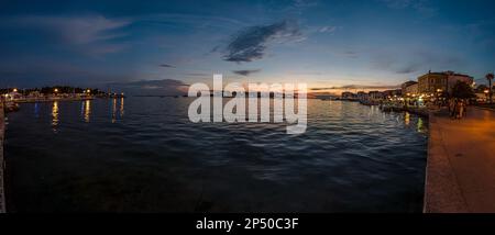 Immagine del tramonto colorato dal porto della città costiera croata di Porec in estate Foto Stock