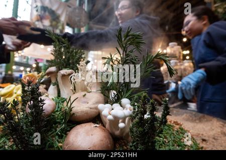 Stand gastronomico a Borough Market, Londra UK, che vende risotti di funghi selvatici da take away preparati al momento con farro. Funghi selvatici in primo piano. Foto Stock