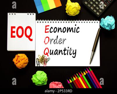 Simbolo quantità ordine economico EOQ. Concetto parole EOQ ordine economico quantità su bianco nota su bellissimo sfondo nero. Matita e penna. Business EO Foto Stock