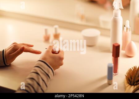 Ritagliato di donna che fa manicure a casa, applicando smalto per unghie Foto Stock