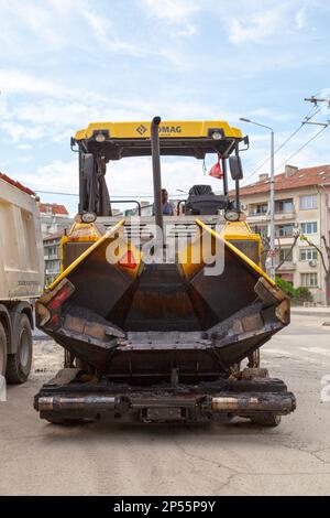 Varna, Bulgaria - 16 2019 maggio: Un alimentatore Bomag in attesa è il turno di stendere asfalto su una strada del centro. Foto Stock