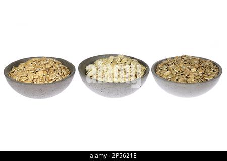 fiocchi di cereali (farro, avena, segale) in ciotole di cemento isolate su fondo bianco Foto Stock