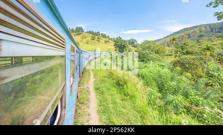 La locomotiva del treno diesel da Ella a Kandy si snoda attraverso la campagna dello Sri Lanka Foto Stock