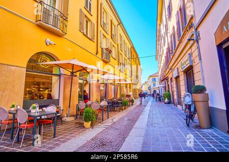 MONZA, ITALIA - 11 APRILE 2022: Piccoli caffè con tavoli all'aperto lungo Via Carlo Alberto, la via pedonale centrale, il 11 aprile a Monza, Italia Foto Stock