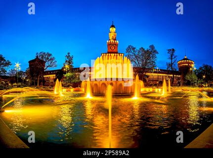 Panorama della fontana illuminata prima della facciata principale del Castello Sforzesco a Milano Foto Stock