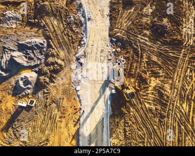 Vista dall'alto verso il basso dell'area di costruzione con terreno e terreno in fase di preparazione per la costruzione di edifici Foto Stock