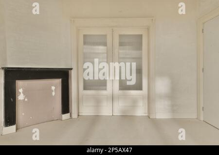 una stanza vuota con due porte e un caminetto al centro di una porta è chiusa, un'altra è dipinta di bianco Foto Stock